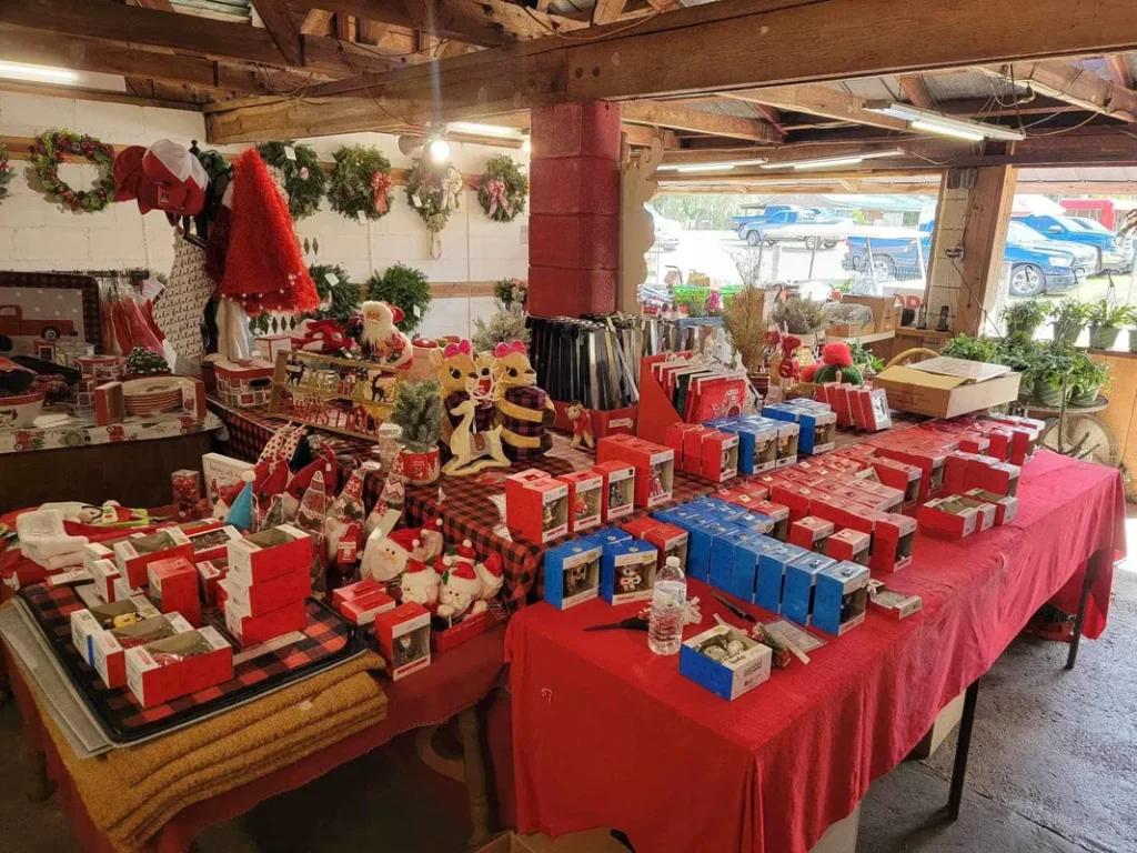 Ornaments and gifts on red tables in the gift barn