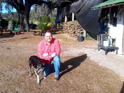 Man kneeling with Lucy in the farm yard